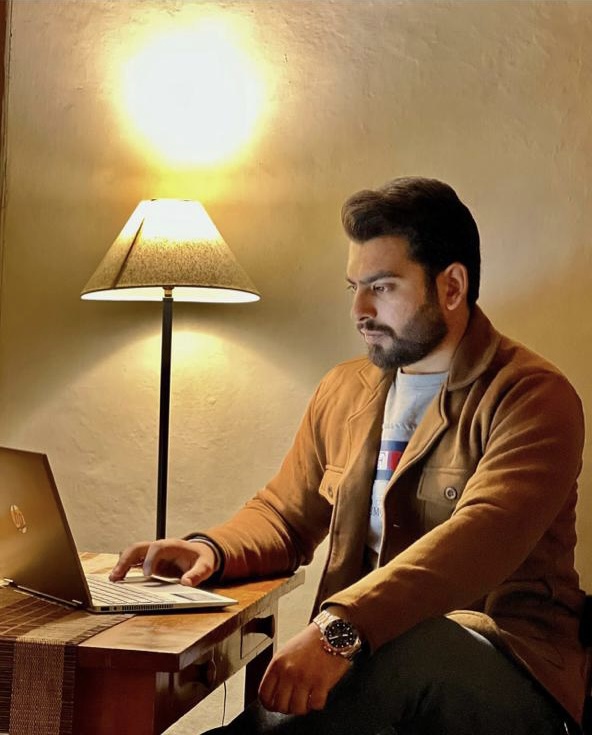 a man sitting at a desk with a laptop